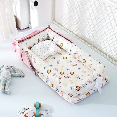 Cocon pour bebe à motifs animaux, posé sur lit blanc avec coussin intégré, jouets lapin en peluche et livre autour, dans une chambre douce et sécurisante.