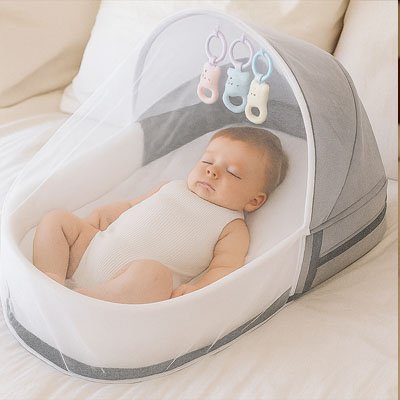 Bébé endormi dans un lit bebe de voyage gris et blanc avec moustiquaire et jouets suspendus, installé dans un intérieur douillet et sécurisé.
