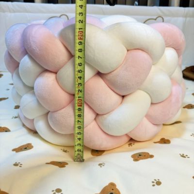 Tour de lit tressé : tresse douce rose et blanche mesurée à 22 cm de hauteur, posée sur matelas à motifs oursons. Confort et sécurité pour lit bébé.