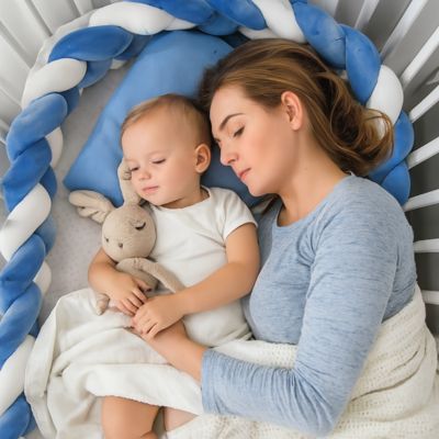Tresse de lit bébé : bébé endormi avec sa maman dans un berceau blanc, tresse bleue et blanche, oreiller moelleux, couverture douce et doudou lapin. Instant paisible et sécurisé.