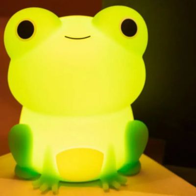veilleuse pour bebe grenouille allumé sur une table