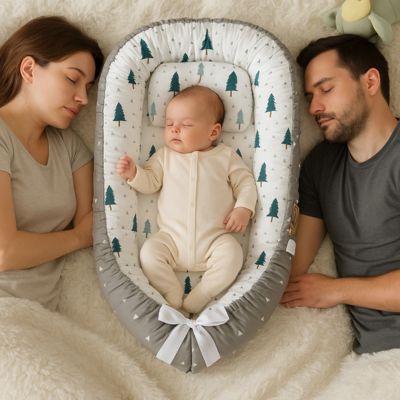 un bébé qui dors dans un reducteur de lit entre ces parents dans le meme lit que ces parents.