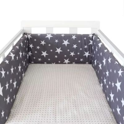 Tour de lit berceau blanc avec tour de lit bleu à étoiles, matelas à pois. Ambiance douce et sécurisée pour le sommeil de bébé.