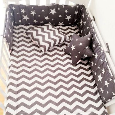 Tour de lit berceau blanc avec tour de lit bleu étoile blanc, matelas à chevrons et coussins assortis. Design moderne et sécurisant pour bébé.