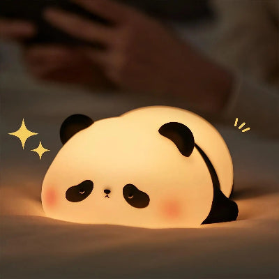 veilleuse panda illuminé sur un matelas blanc